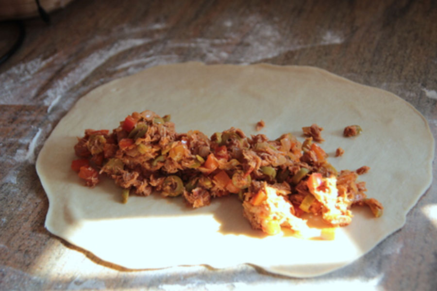 רדדו כדור אחד למעין מלבן. ערמו חצי מכמות הבשר (או הטונה!) כגליל באמצע המלבן, לאורך