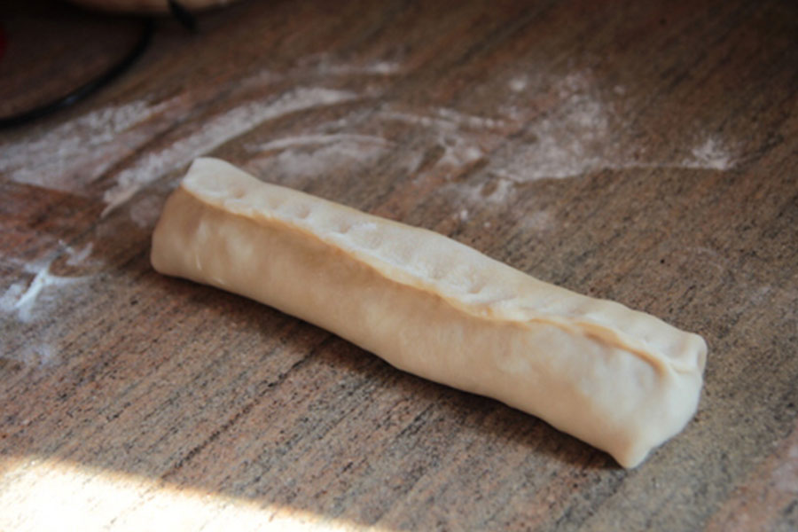 הפכו את הבורקס וצבטו בעזר האצבעות את התפר. חזרו על אותן הפעולות עם כדור הבצק השני